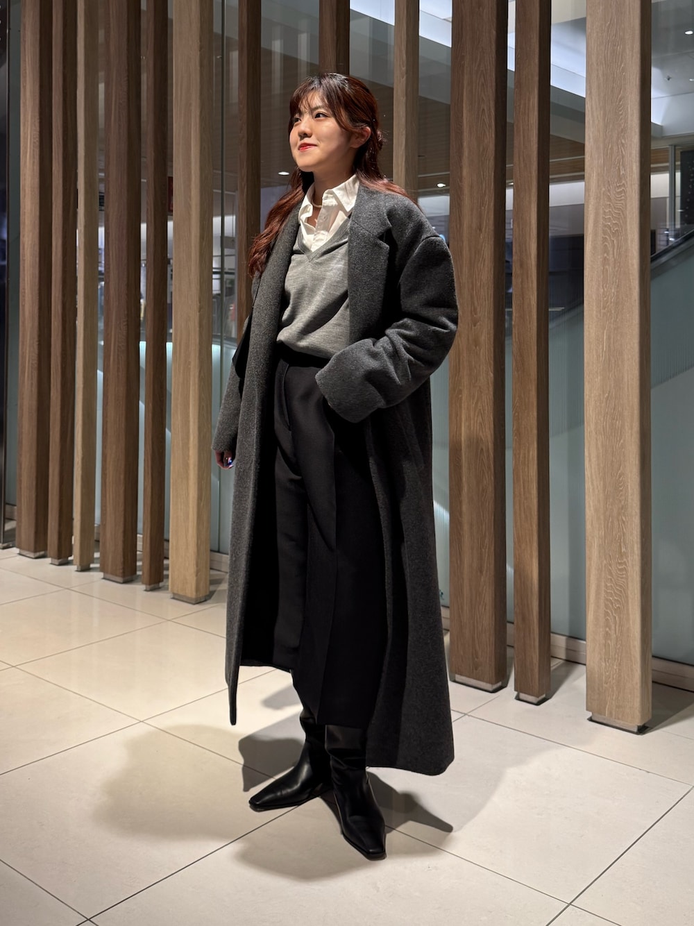 グレー系のニット/セーター、グレー系のチェスターコート、ブラック系のその他パンツを着用したレディースの冬コーディネートの1枚目の写真