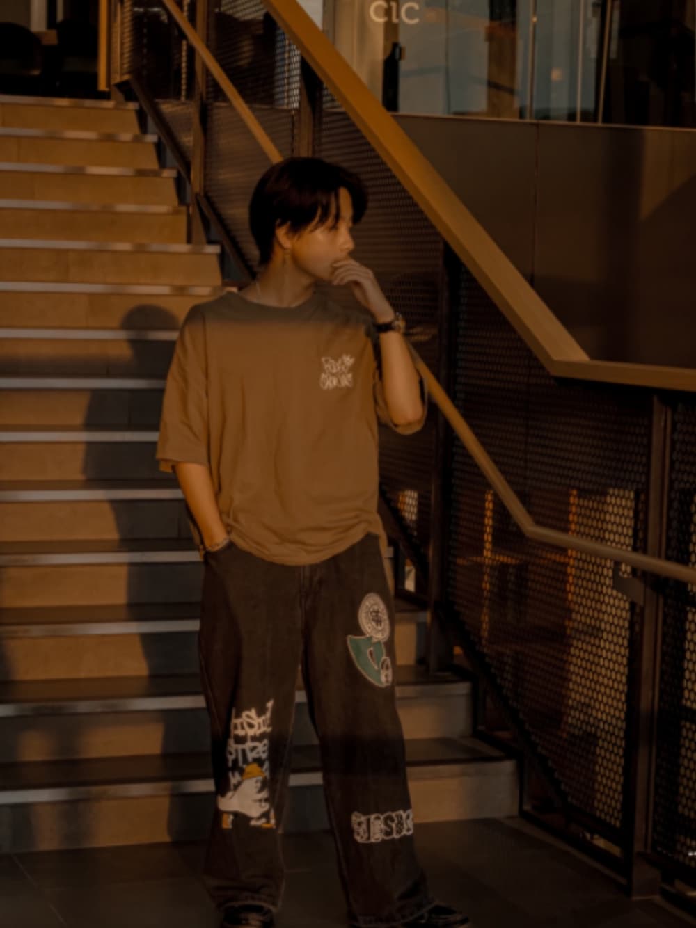 グリーン系のTシャツ/カットソー、ブラック系のデニムパンツを着用したメンズの秋コーディネートの1枚目の写真