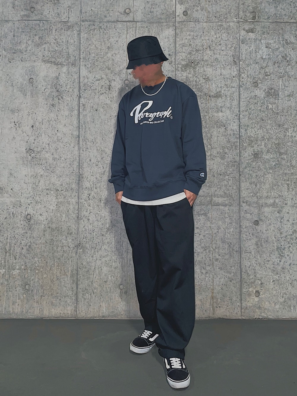 ブラック系のスニーカー、ブラック系のパンツ、ホワイト系のトップスを着用したメンズの春コーディネートの1枚目の写真