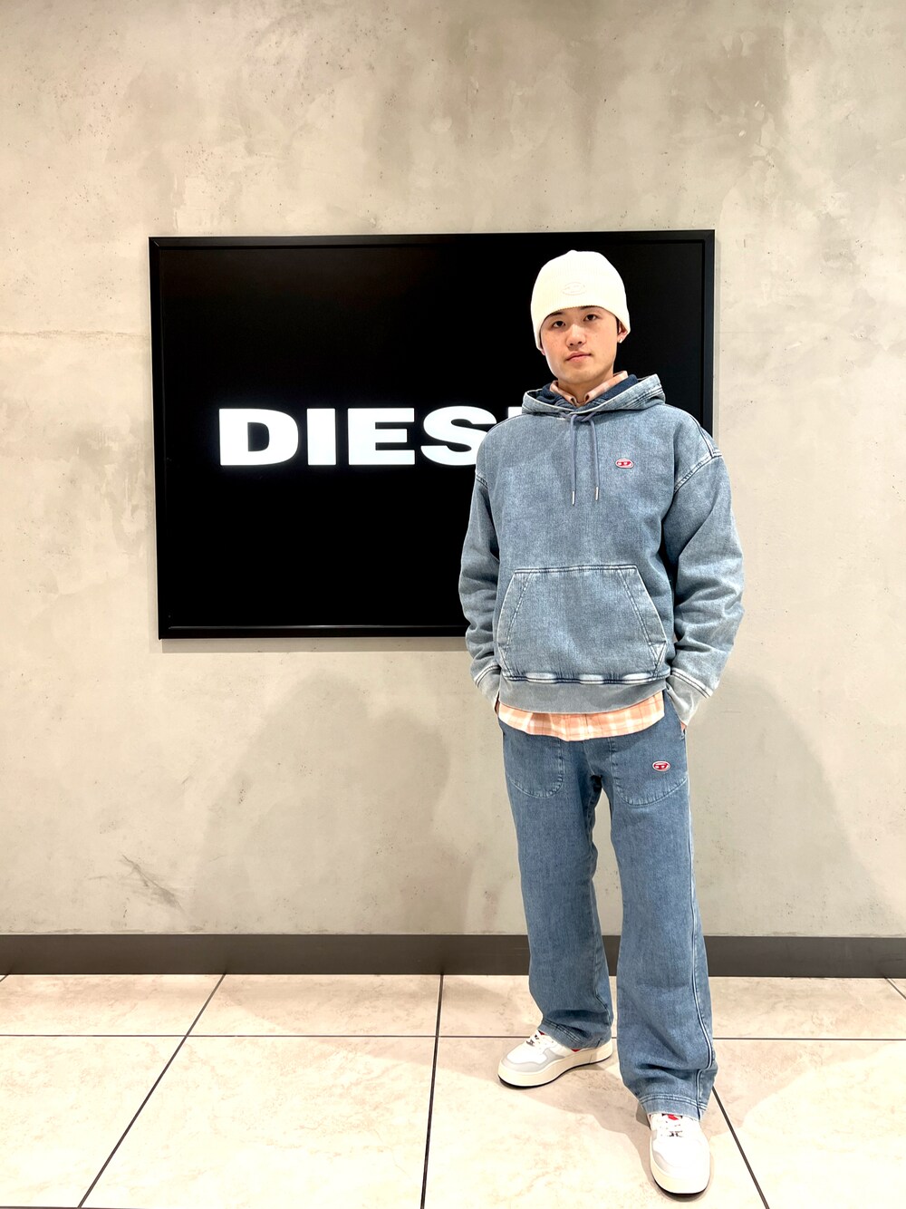 ブルー系のデニムパンツ、ブルー系のスウェット、ホワイト系のスニーカーを着用したメンズの冬コーディネートの1枚目の写真