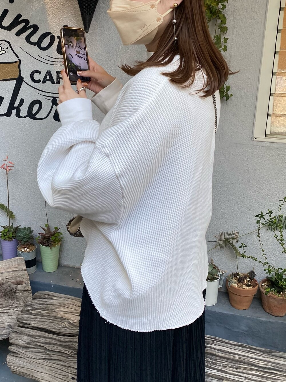 ブラック系のスカート、ホワイト系のTシャツ/カットソー、ブラック系のパンプスを着用したレディースの春コーディネートの2枚目の写真