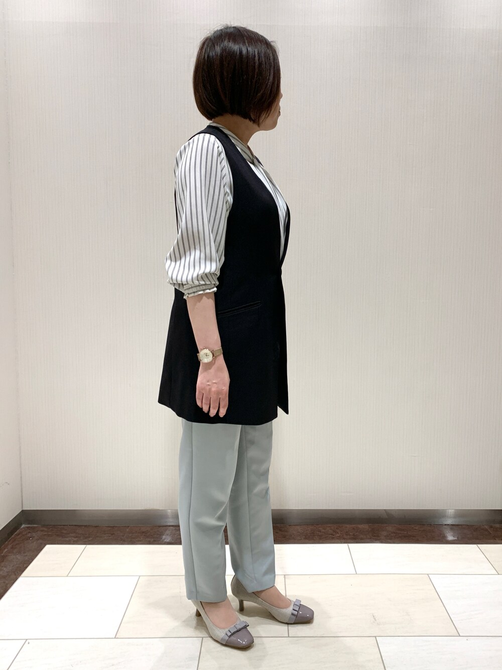 グレー系のパンプスを着用したレディースの春コーディネートの1枚目の写真