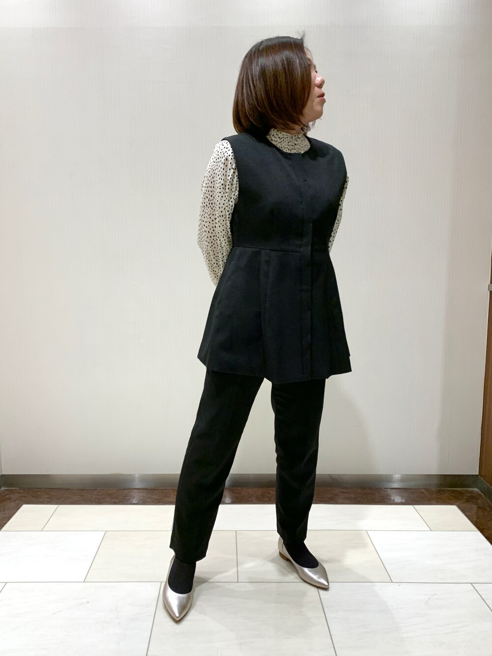 シルバー系のパンプスを着用したレディースの春コーディネートの1枚目の写真
