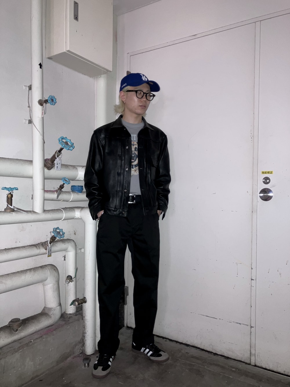 ブラック系のライダースジャケット、グレー系のTシャツ/カットソー、ブラック系のチノパンツを着用したメンズの春コーディネートの1枚目の写真