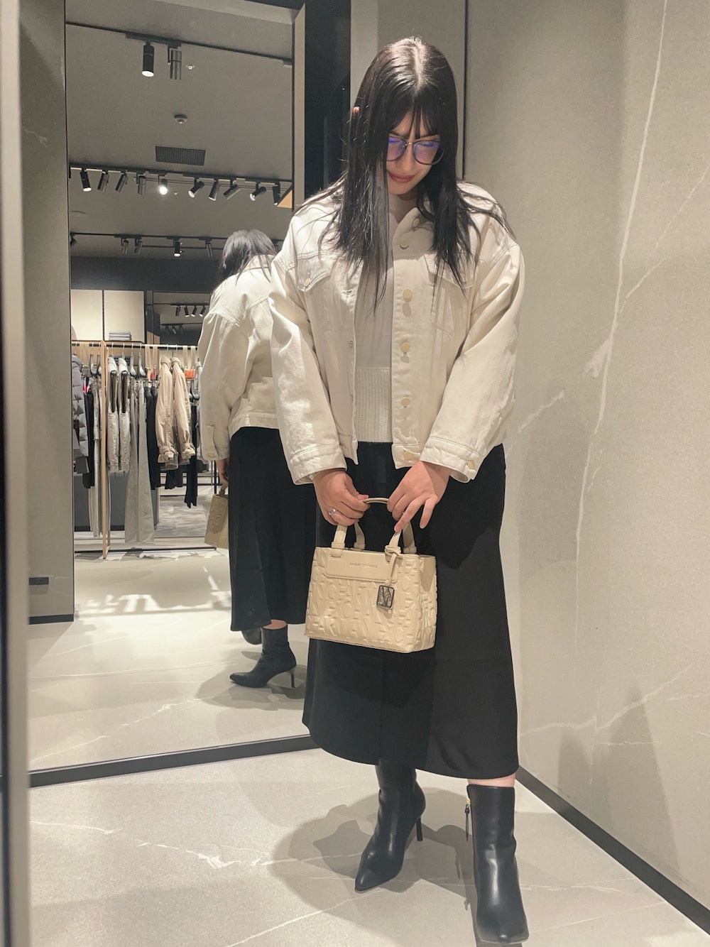 ホワイト系のニット/セーター、ベージュ系のデニムジャケット、ブラック系のブーツを着用したレディースの秋コーディネートの1枚目の写真