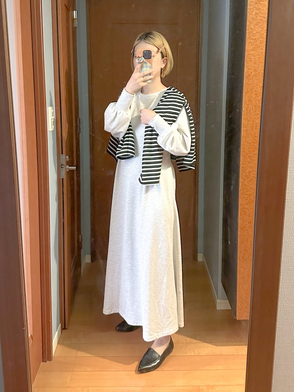 ブラック系のカーディガン/ボレロ、ベージュ系のワンピース、ブラック系のローファーを着用したレディースの冬コーディネートの1枚目の写真