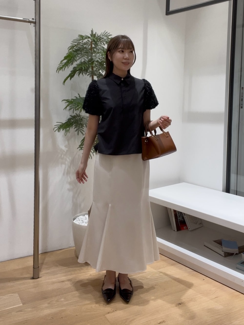 ブラック系のシャツ/ブラウス、ホワイト系のスカート、ブラック系のローファーを着用したレディースの夏コーディネートの1枚目の写真