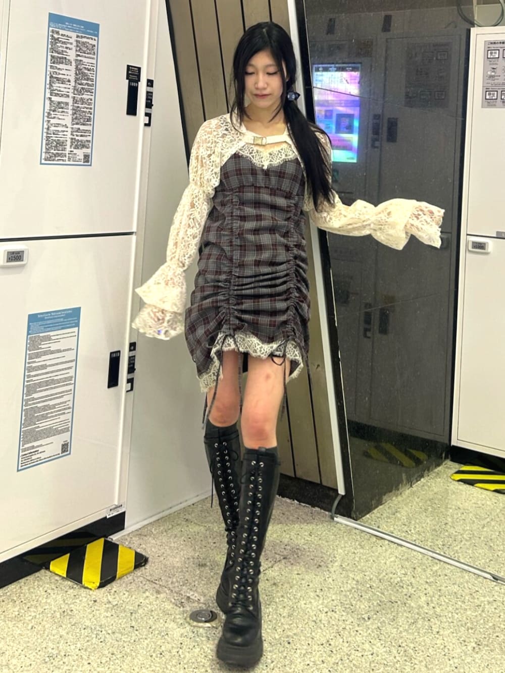 ブラック系のブーツ、ホワイト系のカーディガン/ボレロ、ブラック系のワンピースを着用したレディースの春コーディネートの1枚目の写真