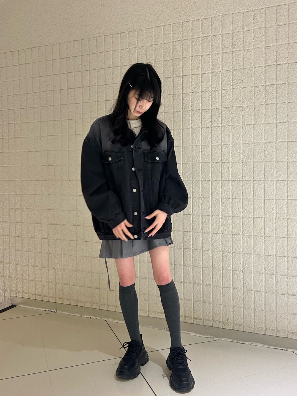 ブラック系のデニムジャケット、ホワイト系のTシャツ/カットソー、グレー系のスカートを着用したレディースの春コーディネートの1枚目の写真