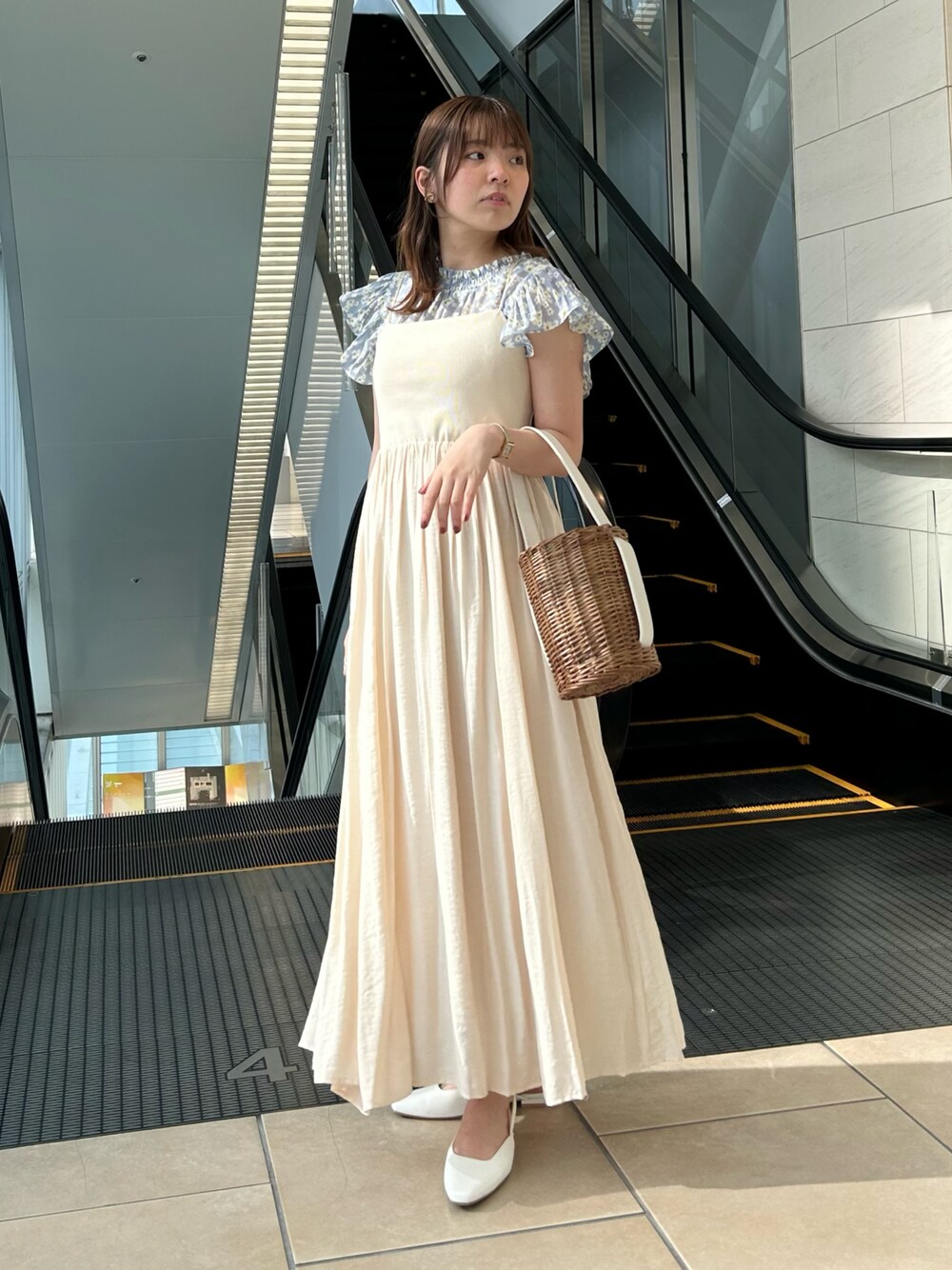 ベージュ系のワンピース、ブルー系のシャツ/ブラウス、ホワイト系のかごバッグを着用したレディースの夏コーディネートの1枚目の写真