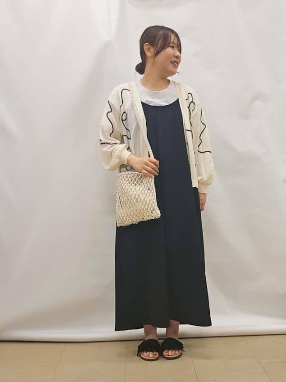 ホワイト系のカーディガン/ボレロ、ブラック系のワンピース、ホワイト系のショルダーバッグを着用したレディースの夏コーディネートの1枚目の写真