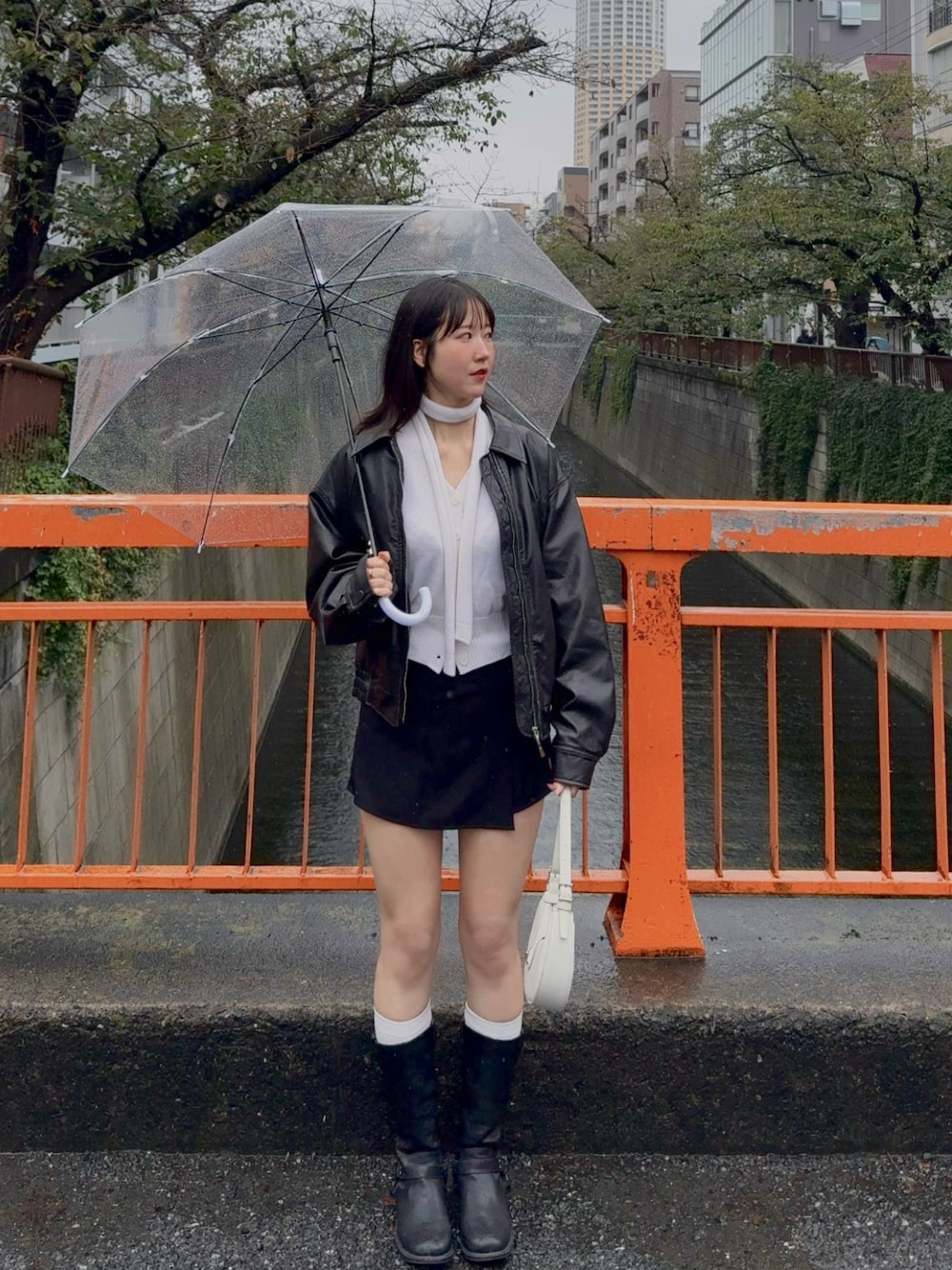 ブラック系のスカート、ブラック系のジャケット/アウター、ホワイト系のカーディガン/ボレロを着用したレディースの秋コーディネートの1枚目の写真