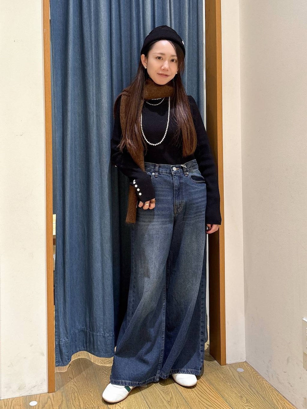 ブラック系のニット/セーター、ブルー系のデニムパンツ、その他のネックレスを着用したレディースの冬コーディネートの1枚目の写真