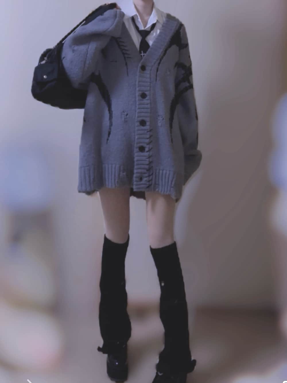 グレー系のカーディガン/ボレロ、グレー系のスカート、ブラック系のショルダーバッグを着用したレディースの秋コーディネートの1枚目の写真