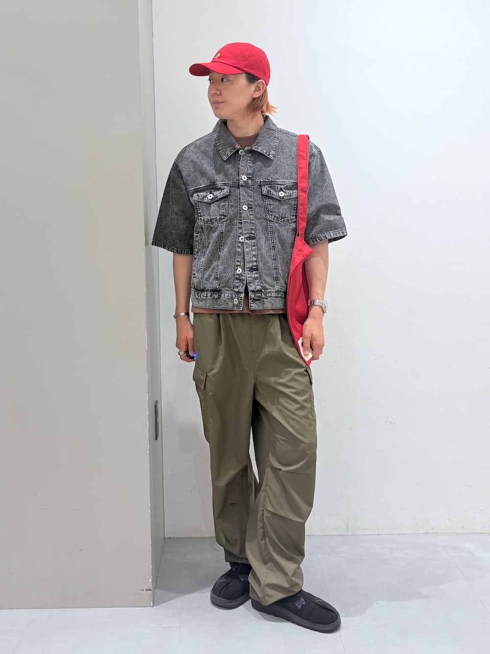 レッド系のトートバッグ、ブラック系のシャツ/ブラウス、ブラウン系のTシャツ/カットソーを着用したメンズの春コーディネートの1枚目の写真
