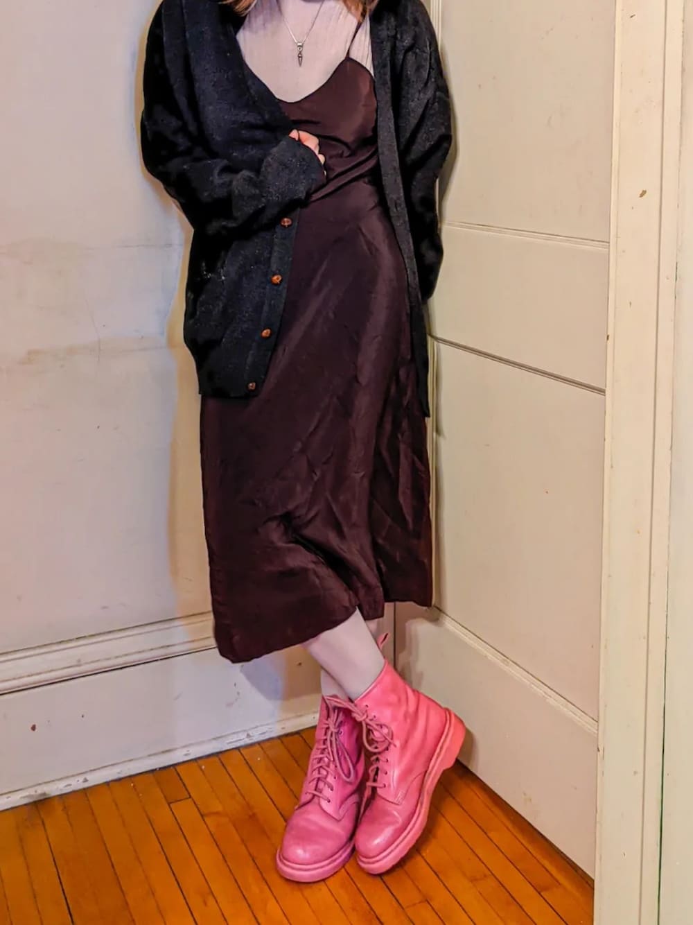 ピンク系のブーツ、グレー系のニット/セーター、ブラック系のカーディガン/ボレロを着用したレディースの冬コーディネートの2枚目の写真