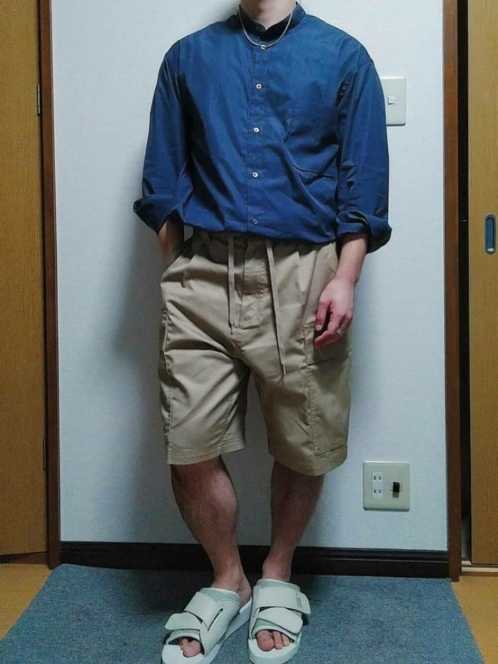 ベージュ系のカーゴパンツ、ホワイト系のサンダル、シルバー系のネックレスを着用したメンズの秋コーディネートの1枚目の写真