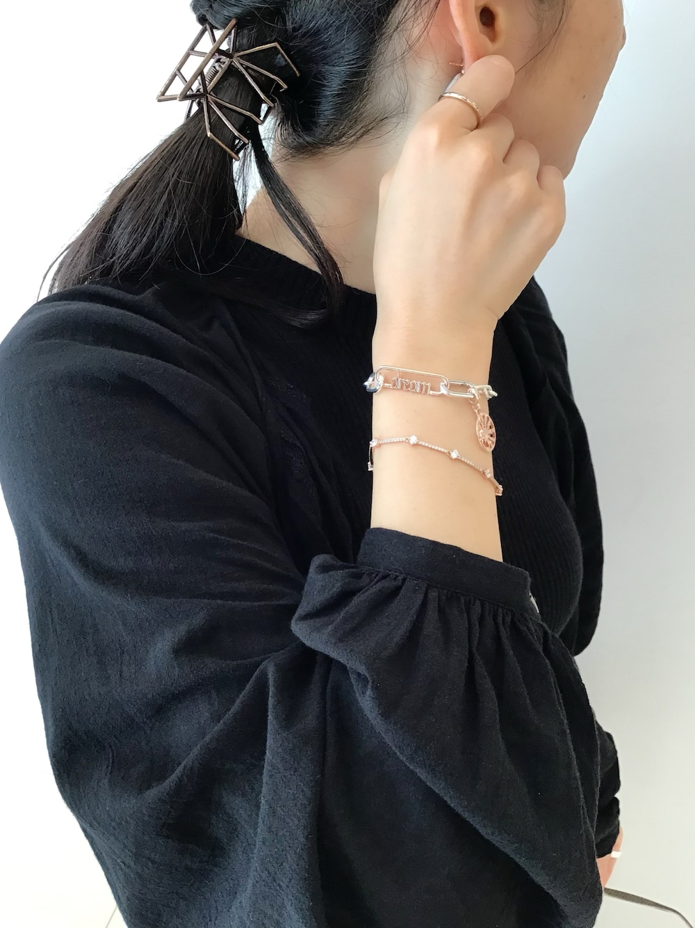 シルバー系のブレスレット、ゴールド系のチャーム、ゴールド系のリングを着用したレディースの冬コーディネートの1枚目の写真