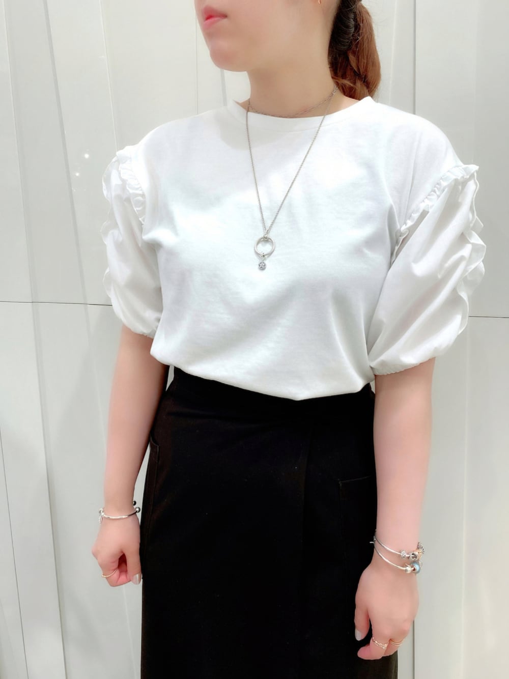 シルバー系のネックレス、シルバー系のブレスレット、ゴールド系のチャームを着用したレディースの夏コーディネートの1枚目の写真