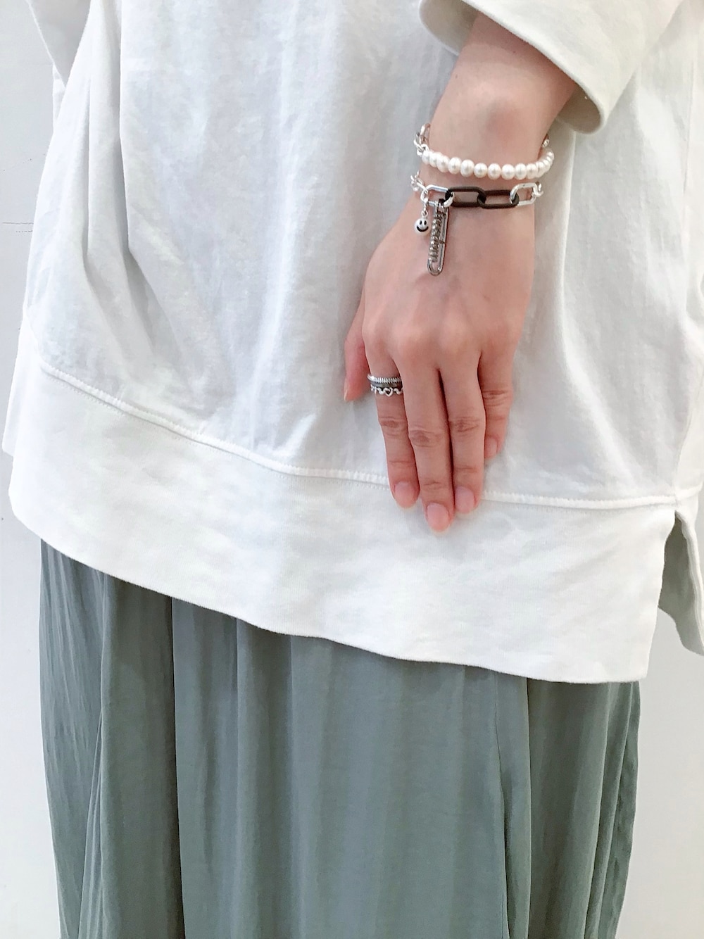 シルバー系のチャーム、ブラック系のチャーム、シルバー系のリングを着用したレディースの秋コーディネートの1枚目の写真