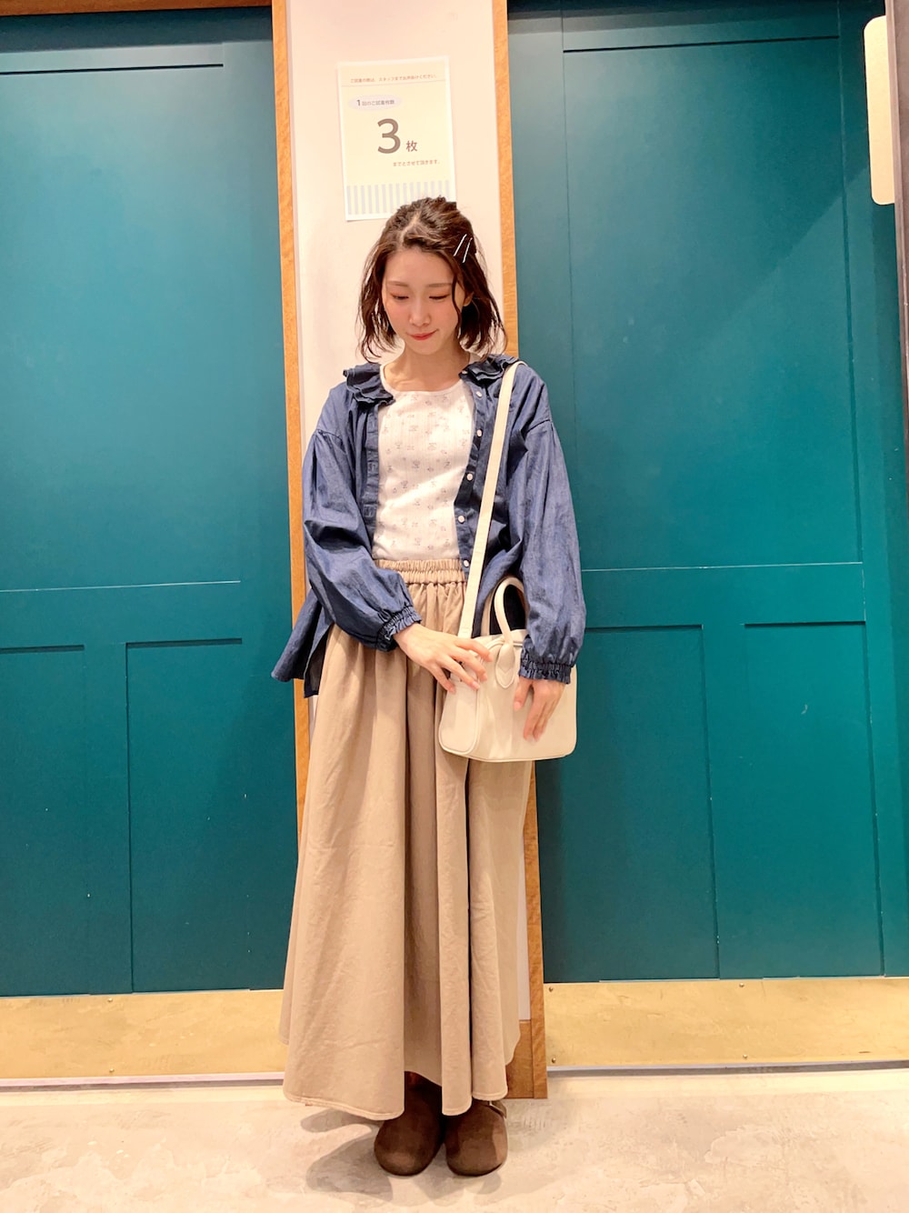 ブルー系のシャツ/ブラウス、ホワイト系のTシャツ/カットソー、ベージュ系のスカートを着用したレディースの春コーディネートの1枚目の写真