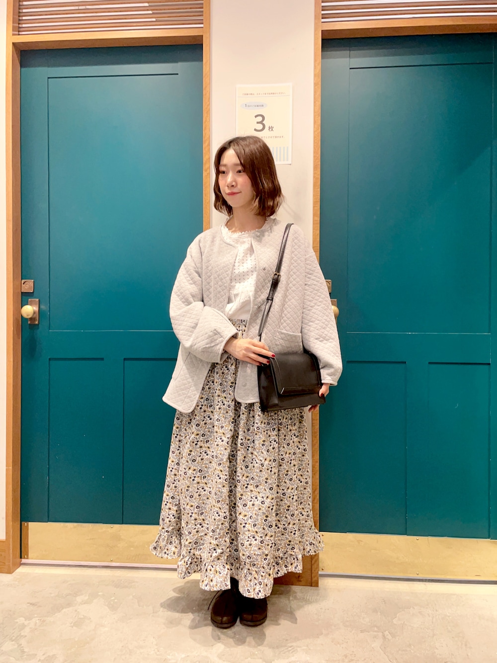 グレー系のノーカラージャケット、グレー系のスカート、ブラウン系のその他シューズを着用したレディースの冬コーディネートの1枚目の写真