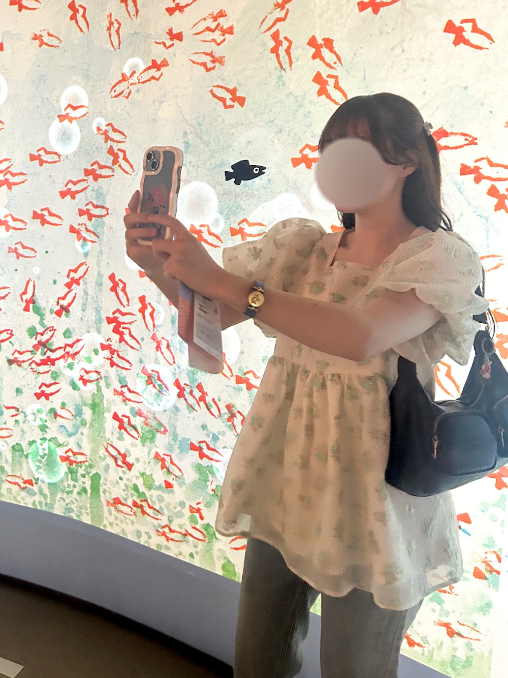 グリーン系のその他トップス、ブルー系のデニムパンツ、ブラック系のスニーカーを着用したレディースの夏コーディネートの1枚目の写真