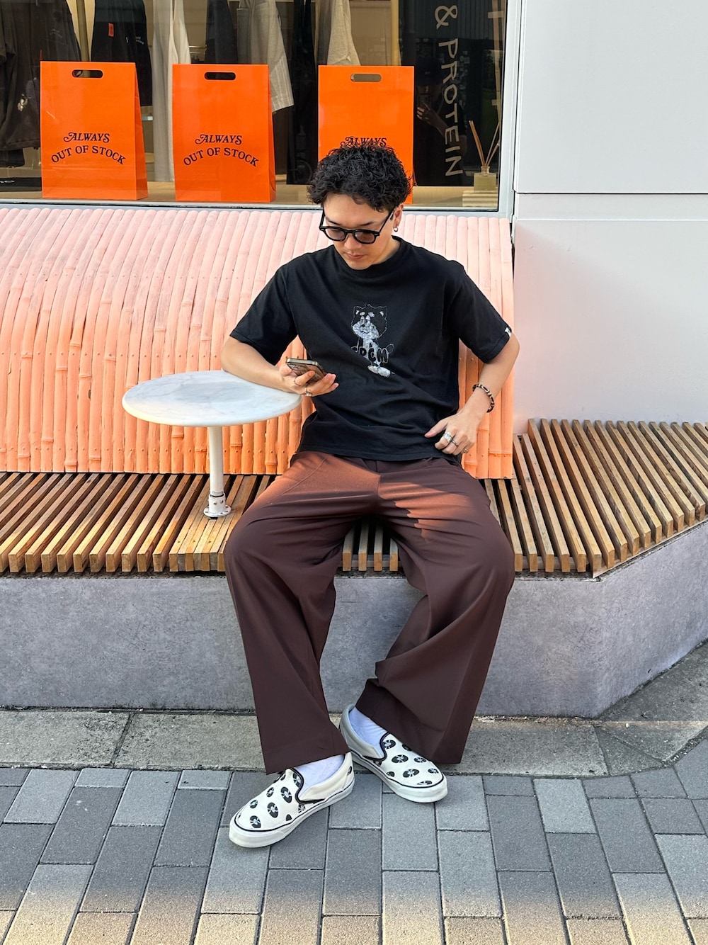 「ロゴT、ブラウン、スリッポン、デートコーデ、テーマパークコーデ、休日スタイル、メガネ男子、スニーカー、シンプルコーデ」｜「CPCMのCPCMマスコットキャラT（Tシャツ/カットソー、ブラック系）」を使った、Ryota Iijimaさん（メンズ・172cm）の夏コーディネートの1枚目の写真