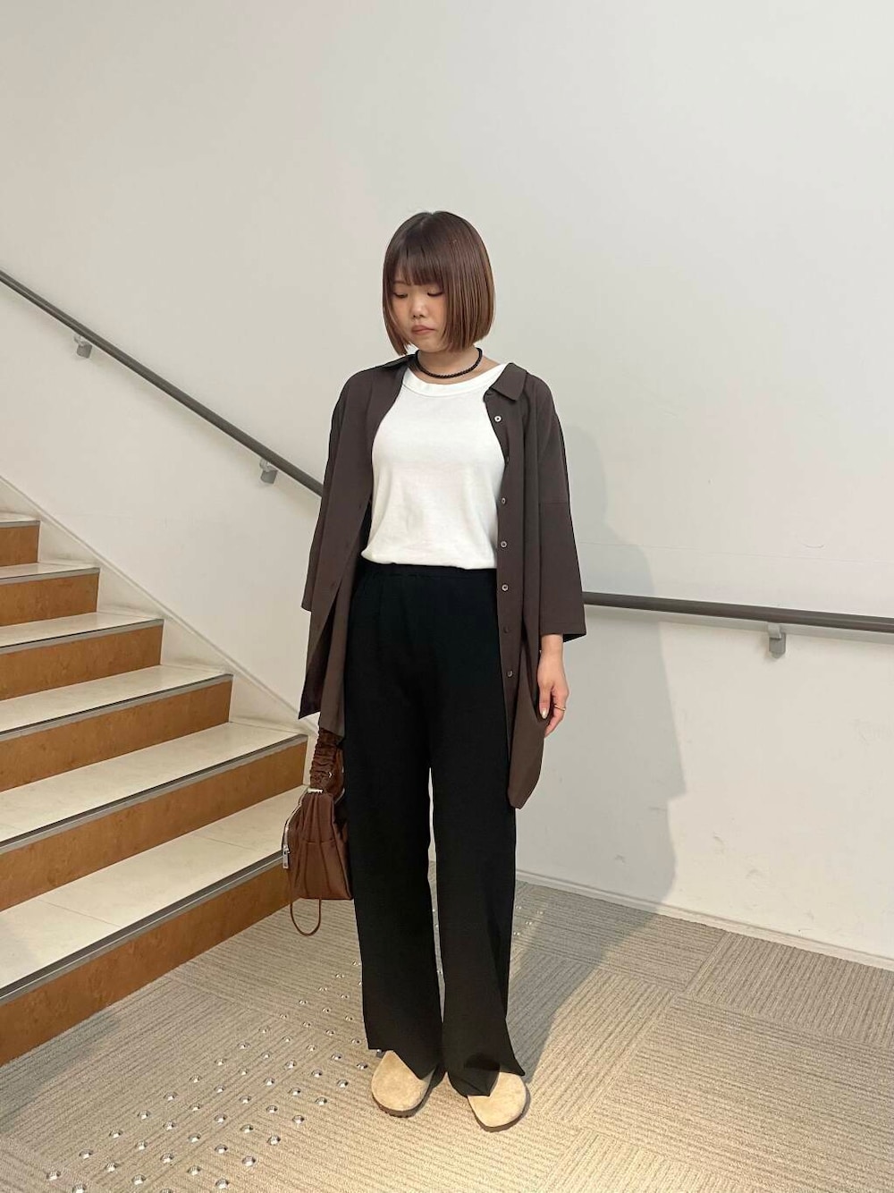 ブラウン系のショルダーバッグ、ベージュ系のサンダル、ブラウン系のシャツ/ブラウスを着用したレディースの夏コーディネートの1枚目の写真