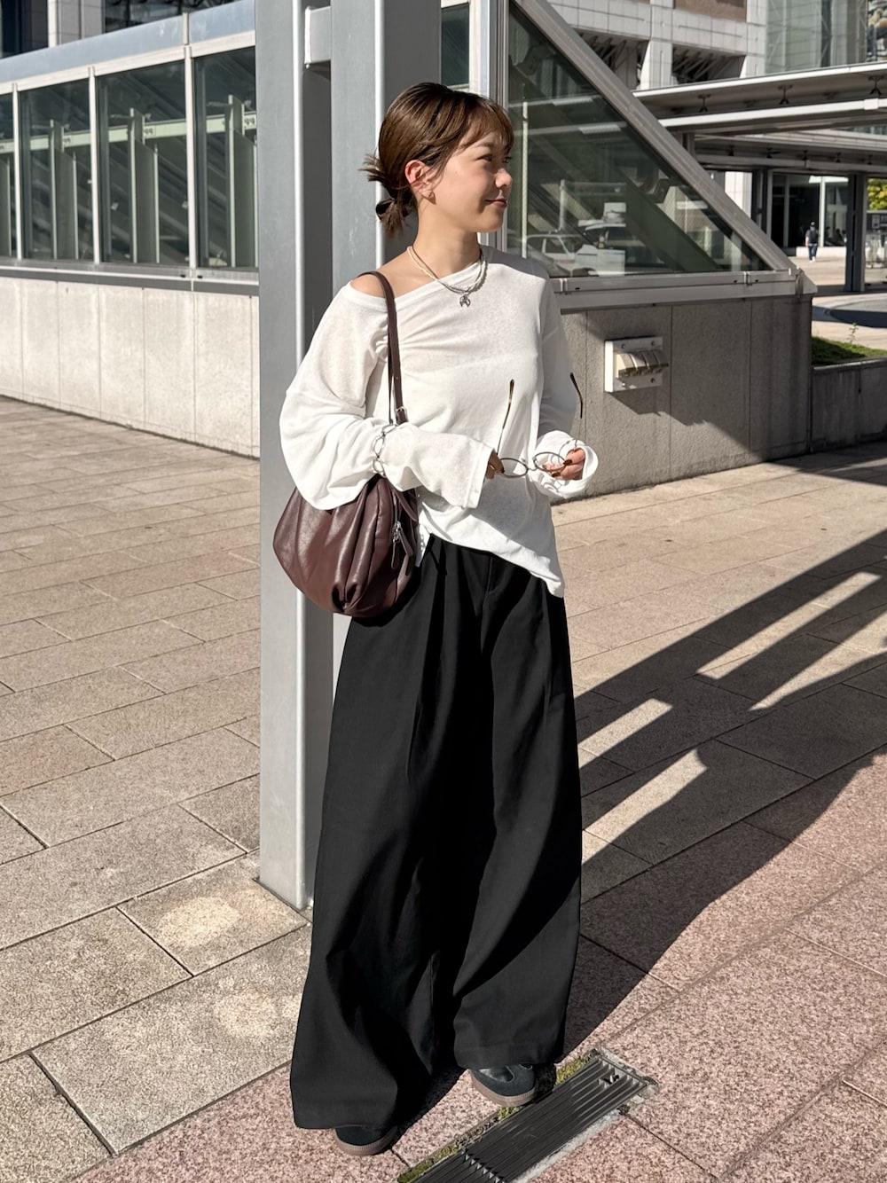 ブラウン系のボストンバッグを着用したレディースの秋コーディネートの1枚目の写真