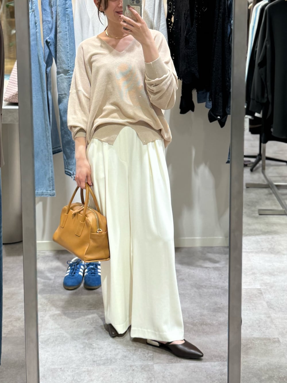 ベージュ系のニット/セーター、ホワイト系のスラックス、イエロー系のボストンバッグを着用したレディースの冬コーディネートの1枚目の写真