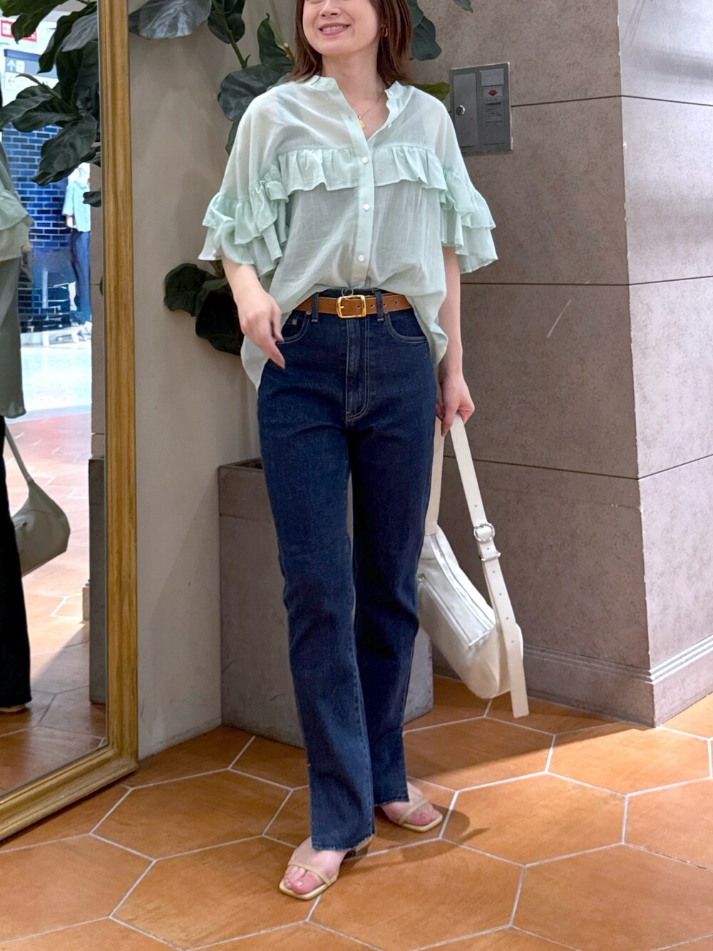 ブルー系のデニムパンツ、ベージュ系のサンダル、グリーン系のシャツ/ブラウスを着用したレディースの夏コーディネートの1枚目の写真