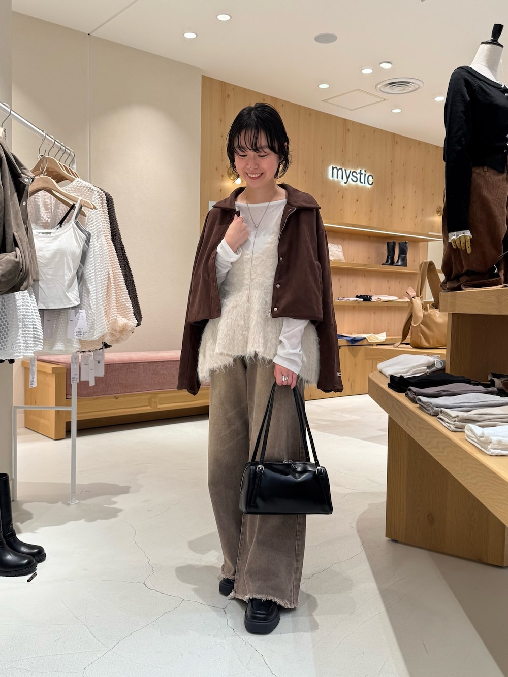 ブラウン系のブルゾン、ホワイト系のベスト、ホワイト系のTシャツ/カットソーを着用したレディースの秋コーディネートの1枚目の写真