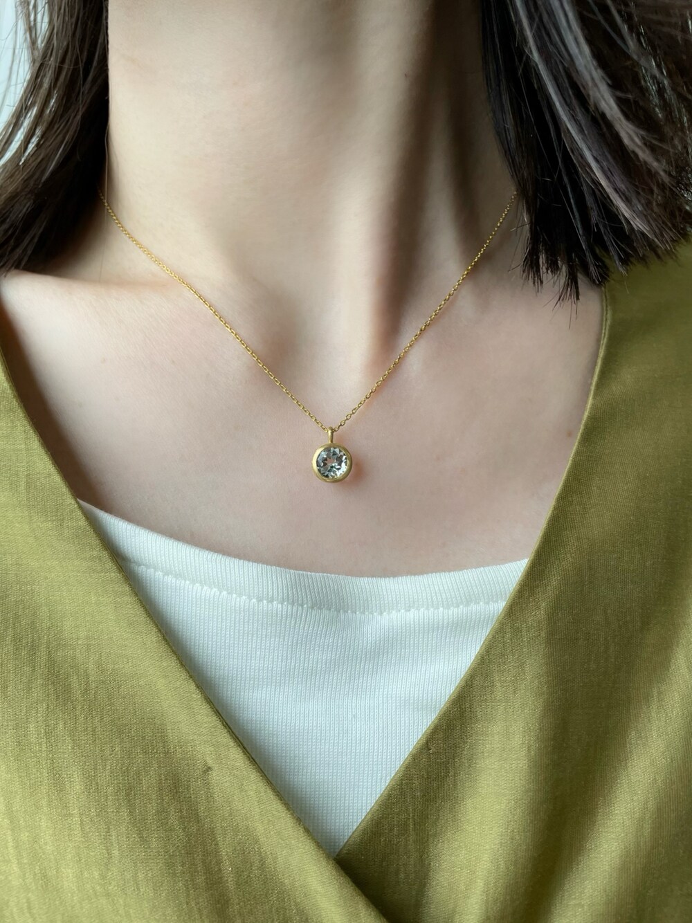 ゴールド系のネックレスを着用したレディースの春コーディネートの1枚目の写真