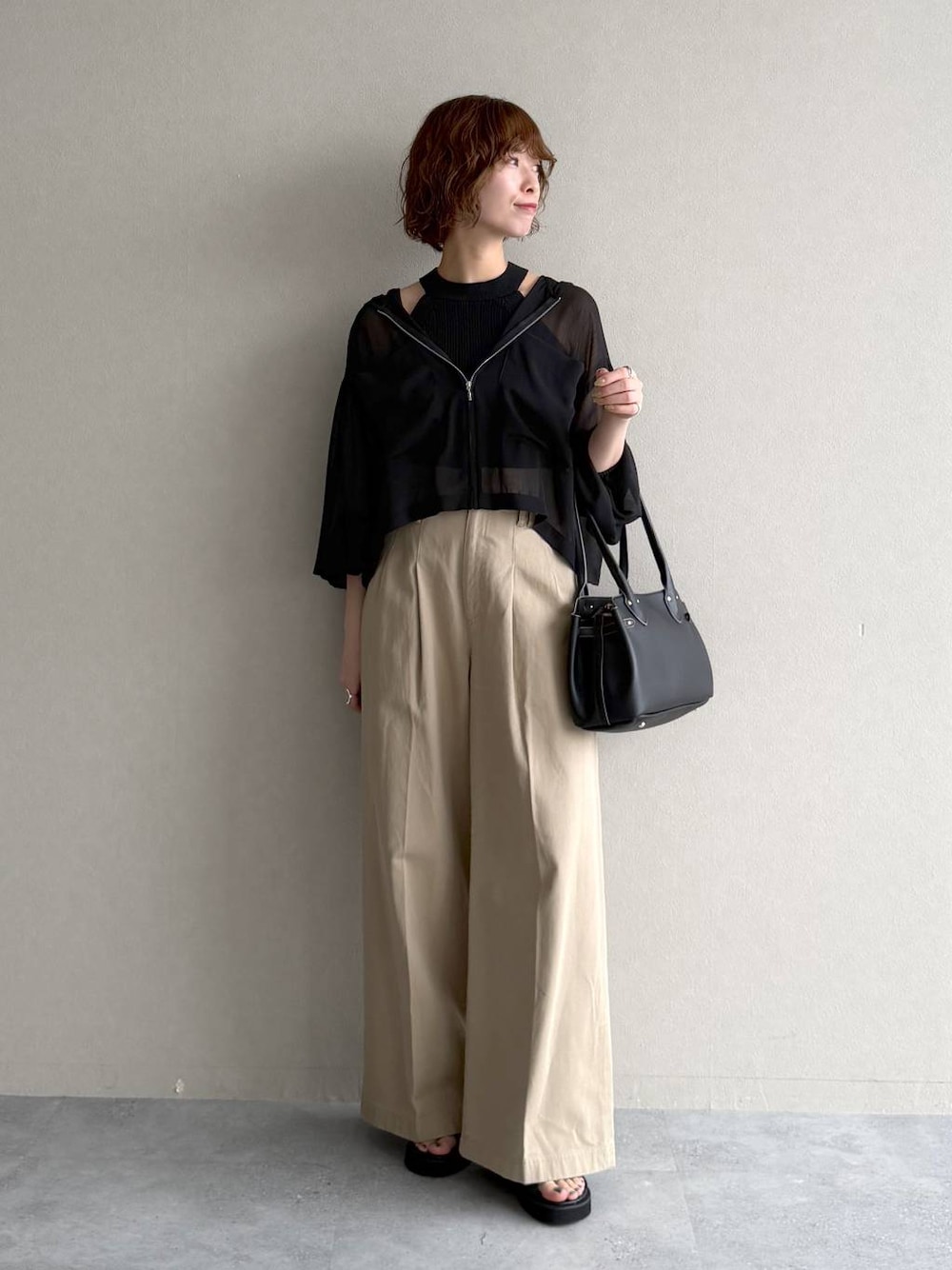 ブラック系のパーカー、ブラック系のサンダル、ブラック系のニット/セーターを着用したレディースの春コーディネートの1枚目の写真