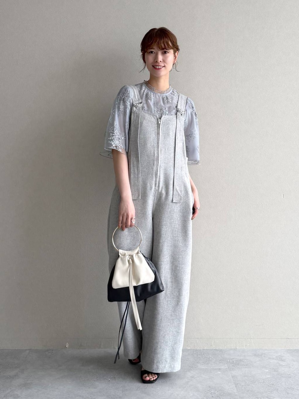 ブルー系のシャツ/ブラウス、ブラック系のハンドバッグ、ブラック系のサンダルを着用したレディースの春コーディネートの1枚目の写真