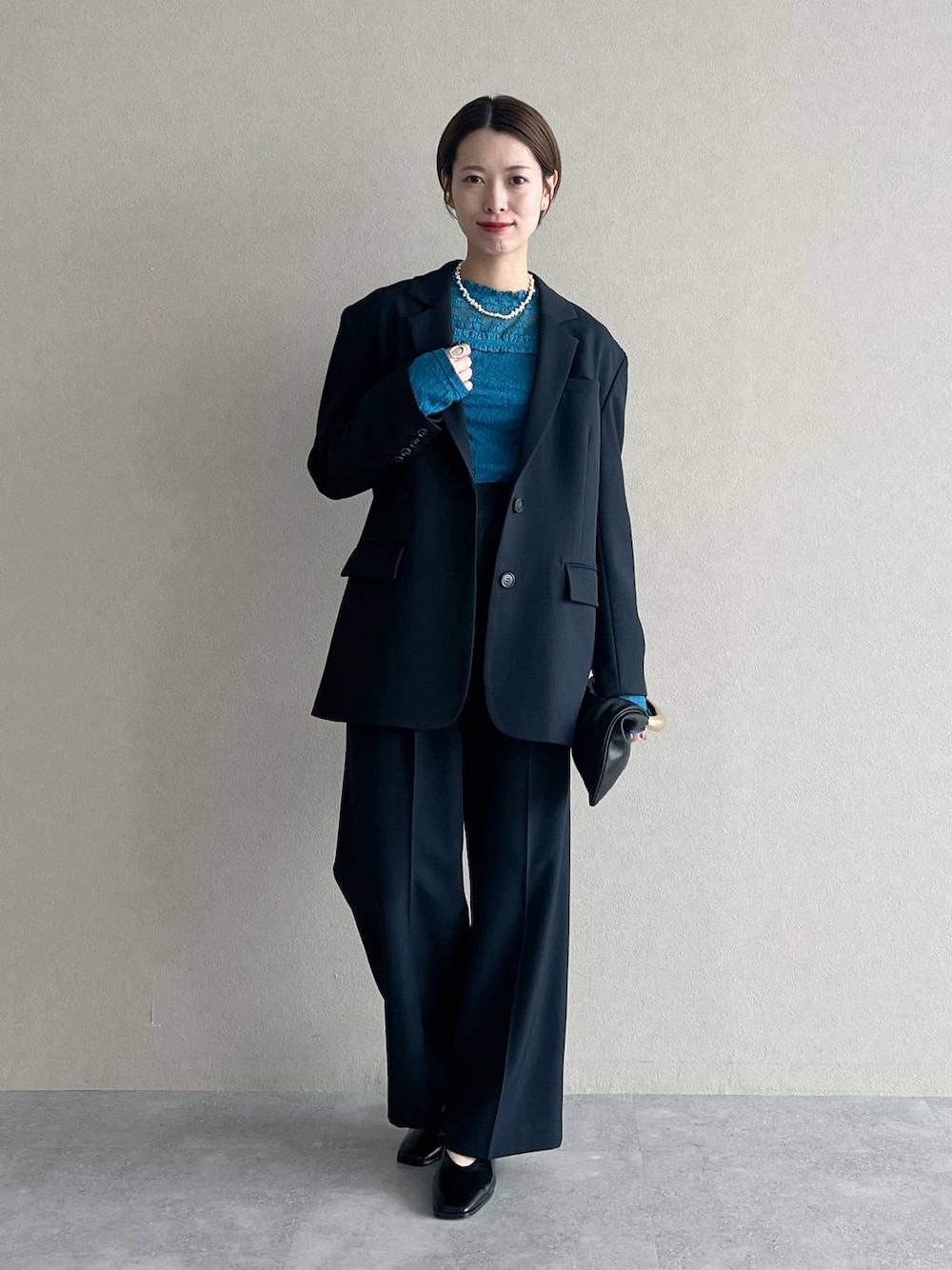 ブラック系のハンドバッグ、ブルー系のTシャツ/カットソー、ブルー系のスラックスを着用したレディースの秋コーディネートの1枚目の写真