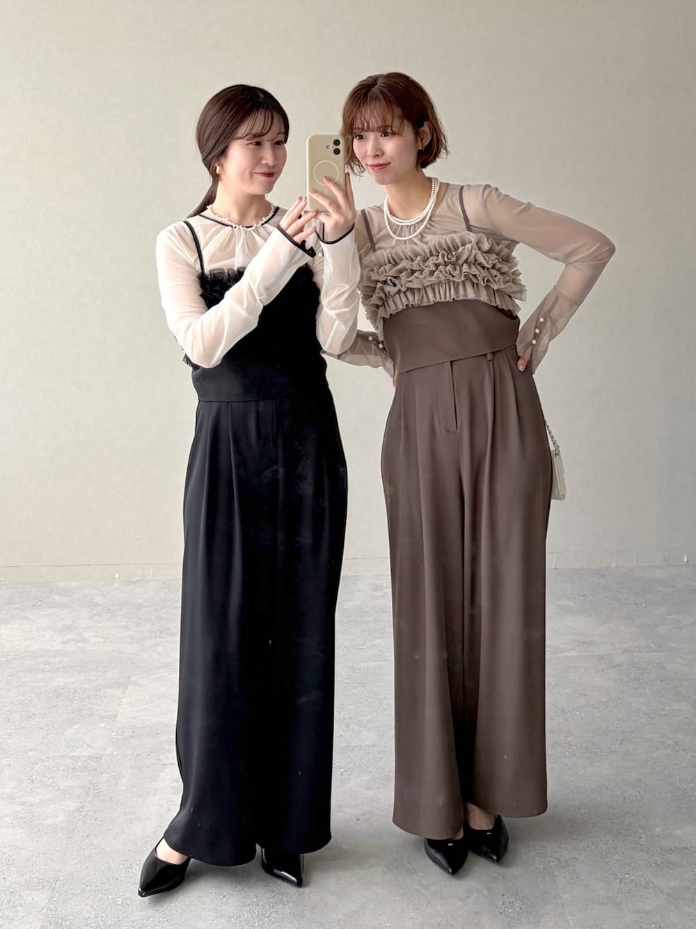 ブラック系のパンプス、ホワイト系のショルダーバッグ、ベージュ系のパンツドレスを着用したレディースの春コーディネートの1枚目の写真