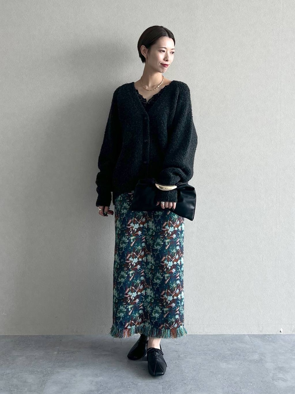 ブラック系のハンドバッグ、グレー系のカーディガン/ボレロ、ブラック系のタンクトップを着用したレディースの秋コーディネートの1枚目の写真