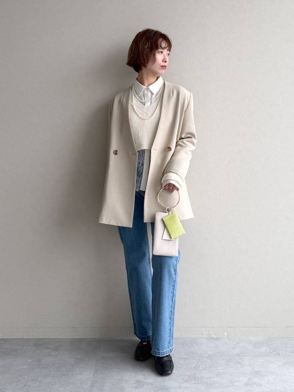 ブラック系のローファー、ブルー系のデニムパンツ、ベージュ系のテーラードジャケットを着用したレディースの冬コーディネートの1枚目の写真