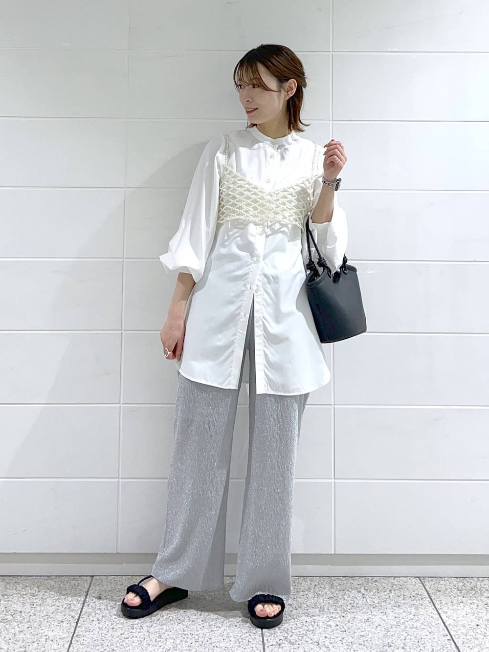 ホワイト系のシャツ/ブラウス、ホワイト系のベスト、ブラック系のサンダルを着用したレディースの春コーディネートの1枚目の写真