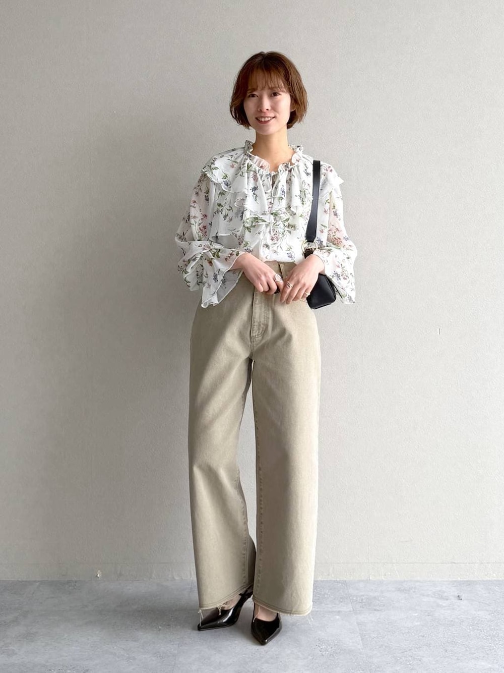 ブラック系のサンダル、ホワイト系のシャツ/ブラウス、ブラック系のショルダーバッグを着用したレディースの春コーディネートの1枚目の写真