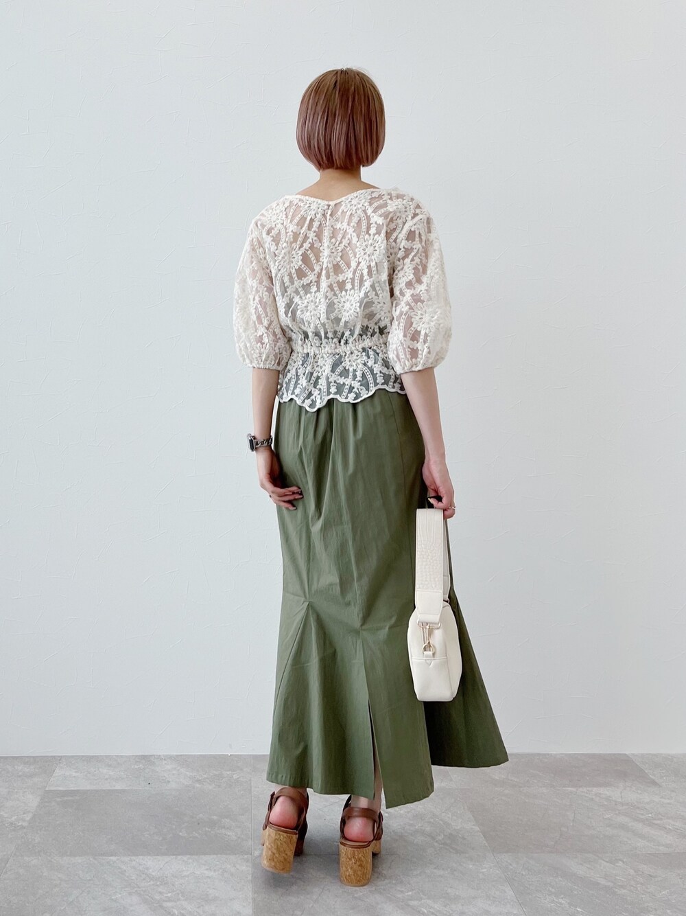 ホワイト系のシャツ/ブラウス、グリーン系のスカート、イエロー系のサンダルを着用したレディースの春コーディネートの3枚目の写真