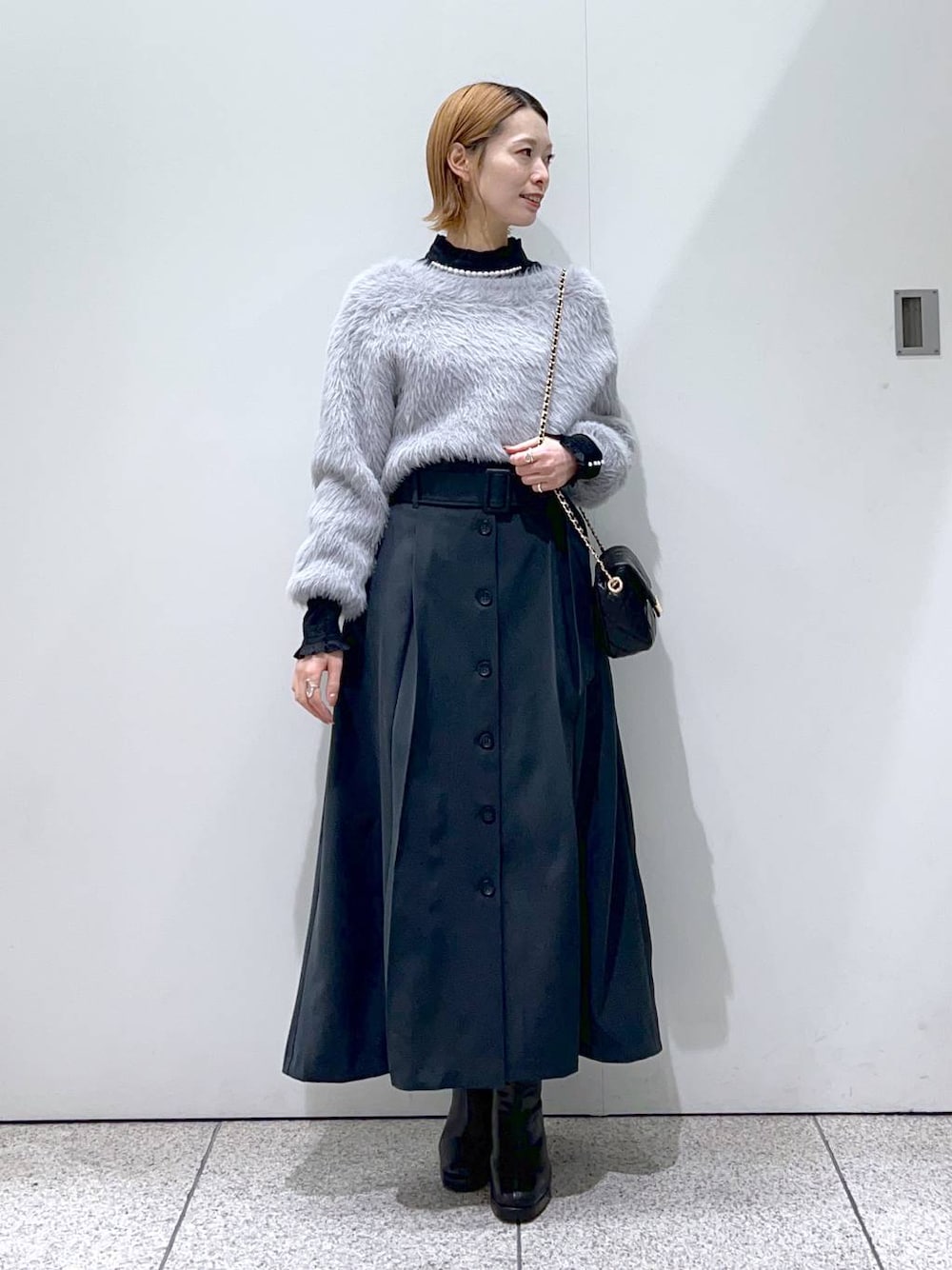 ブラック系のショルダーバッグ、ブラック系のブーツ、ブラック系のシャツ/ブラウスを着用したレディースの冬コーディネートの1枚目の写真