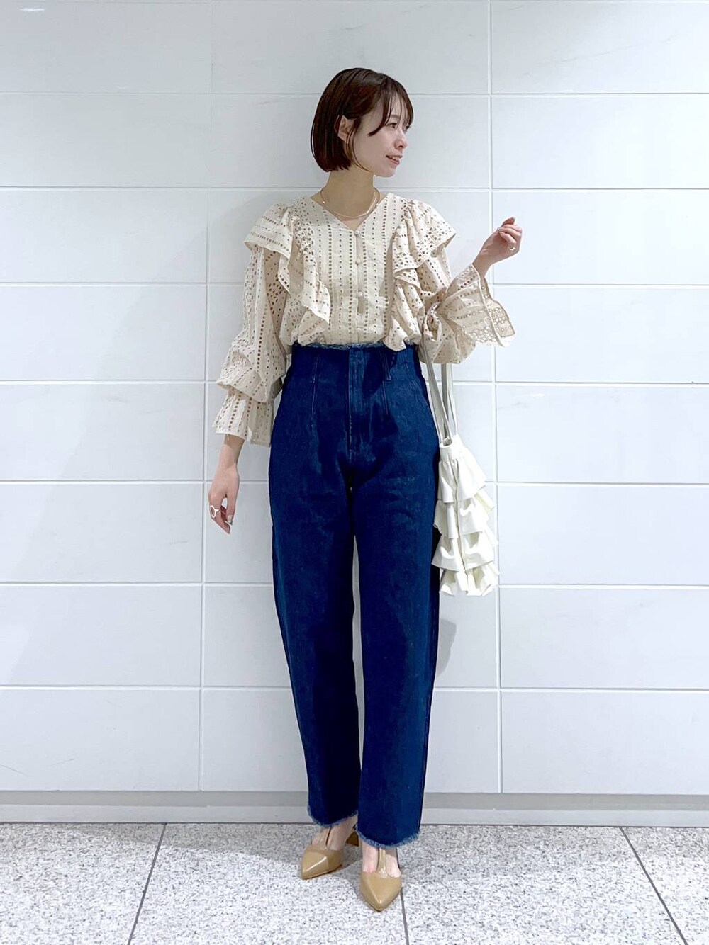 ホワイト系のシャツ/ブラウス、ベージュ系のパンプス、ホワイト系のトートバッグを着用したレディースの冬コーディネートの1枚目の写真