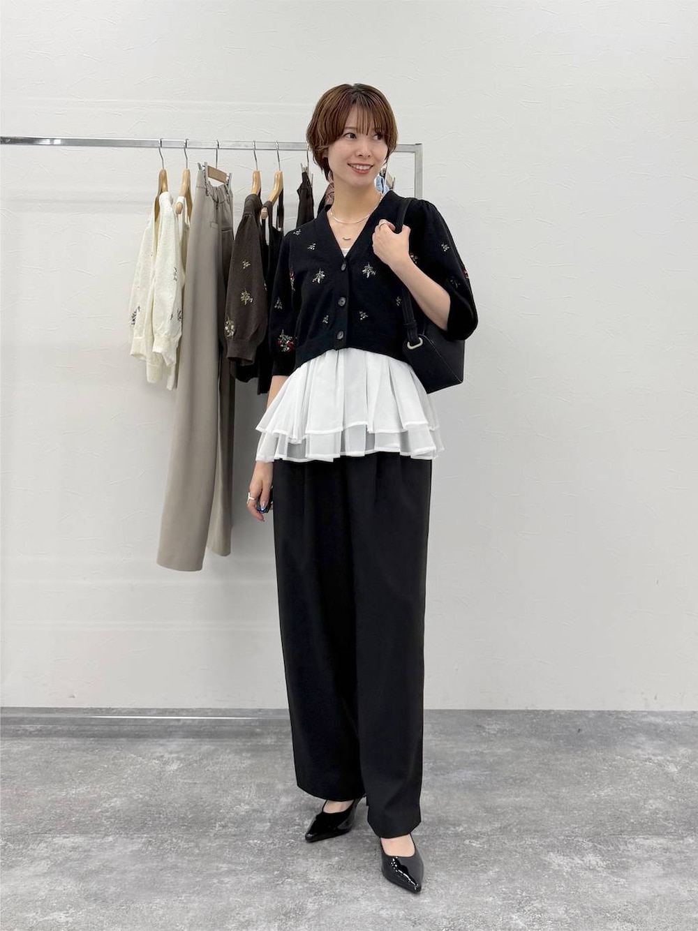 グレー系のニット/セーター、ブラック系のその他パンツ、ブラック系のカーディガン/ボレロを着用したレディースの夏コーディネートの1枚目の写真