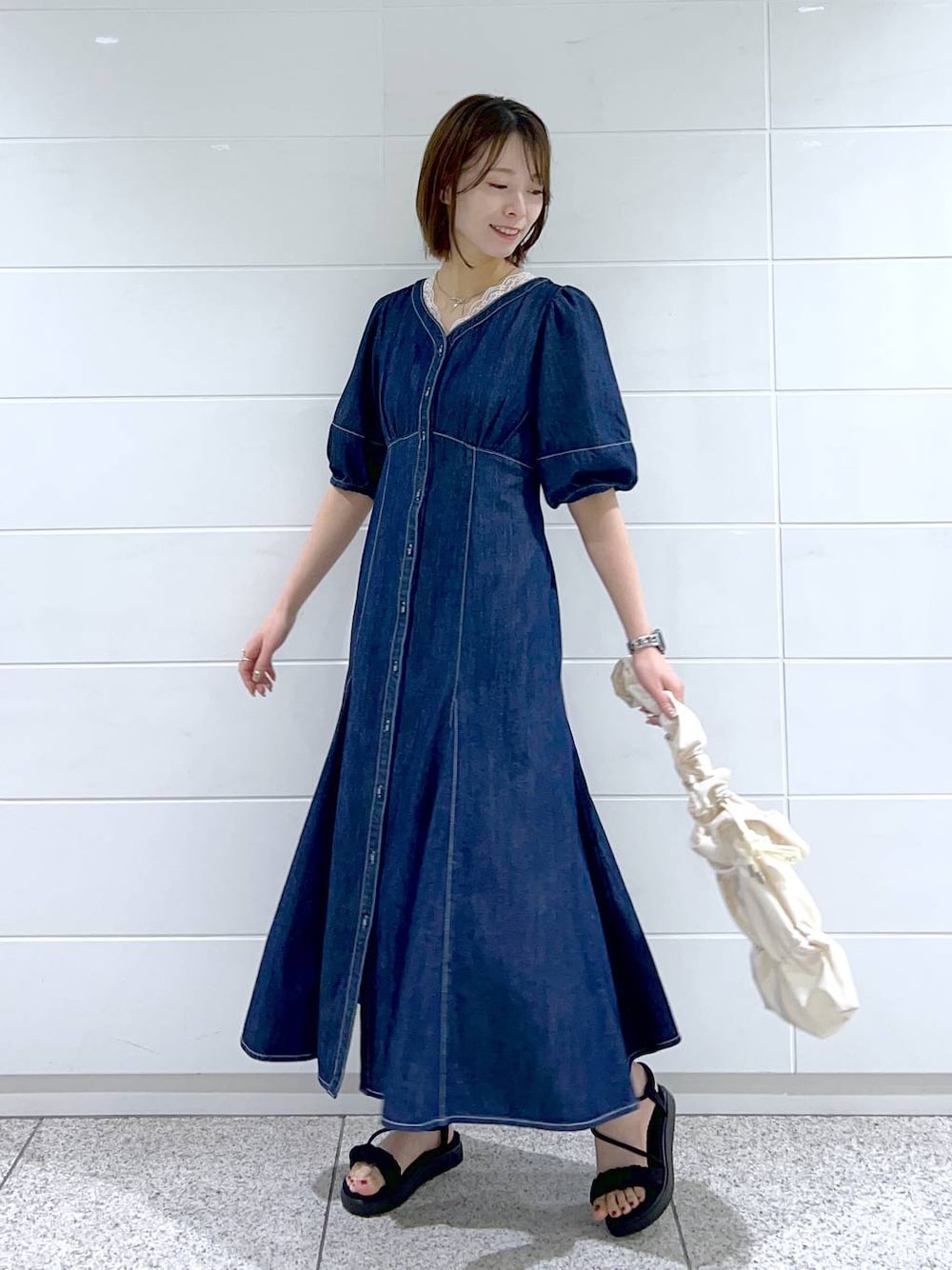 ホワイト系のショルダーバッグ、ホワイト系のタンクトップ、ブルー系のワンピースを着用したレディースの春コーディネートの1枚目の写真