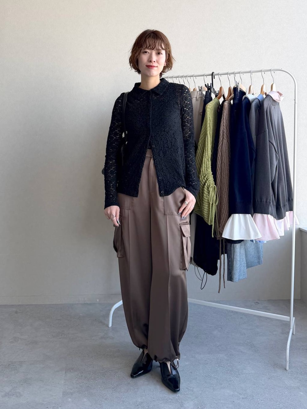 ブラック系のハンドバッグ、ブラック系のサンダル、ブラウン系のその他パンツを着用したレディースの冬コーディネートの1枚目の写真