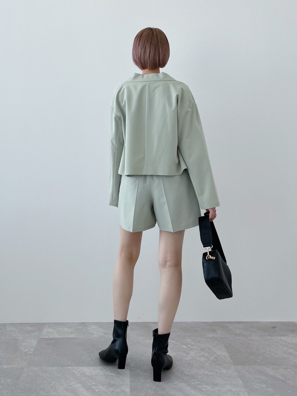 ブラック系のTシャツ/カットソー、グリーン系のテーラードジャケット、グリーン系のその他パンツを着用したレディースの春コーディネートの3枚目の写真