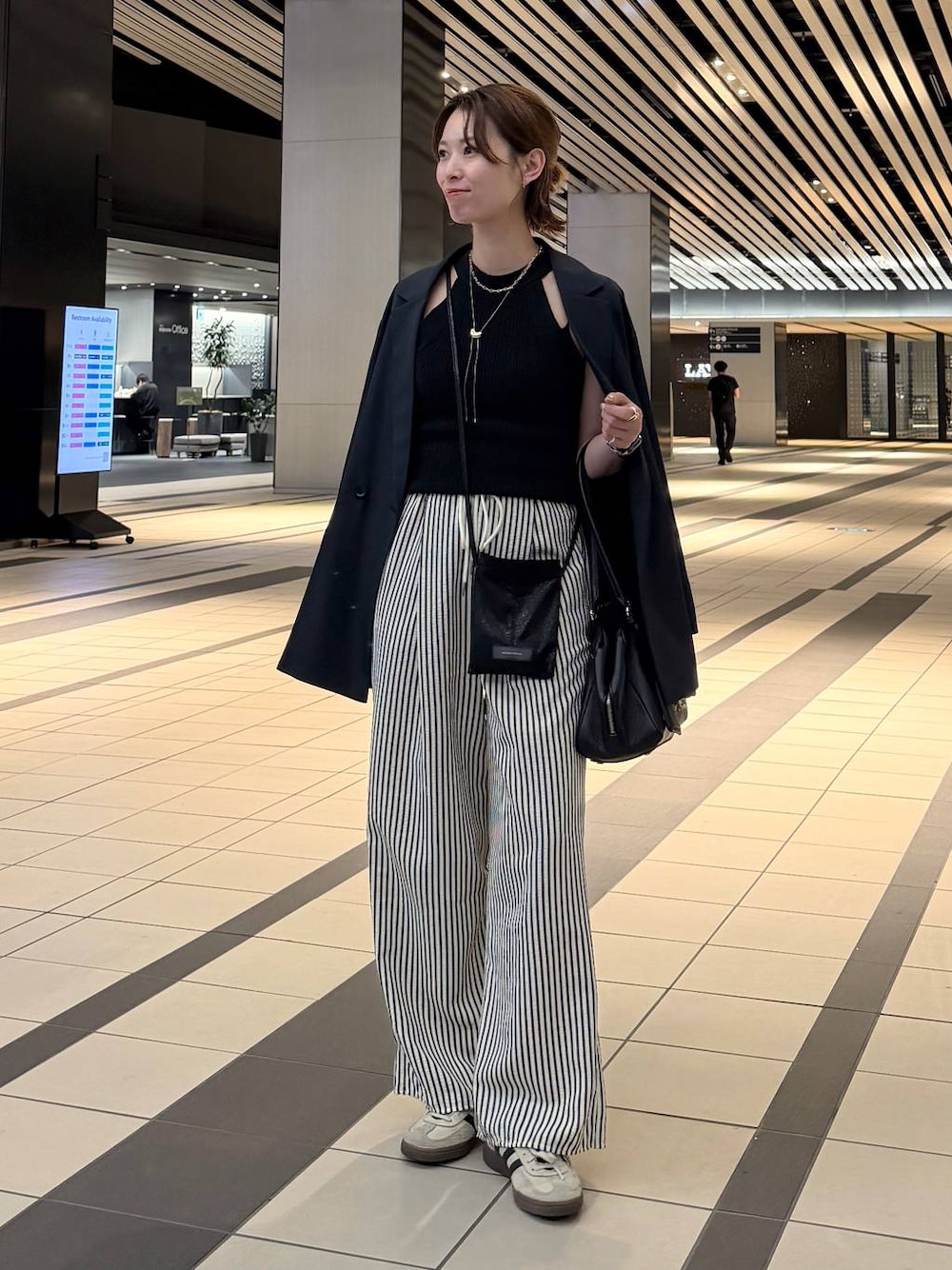 ブラック系のハンドバッグ、ブルー系のその他パンツ、ブルー系のテーラードジャケットを着用したレディースの春コーディネートの1枚目の写真